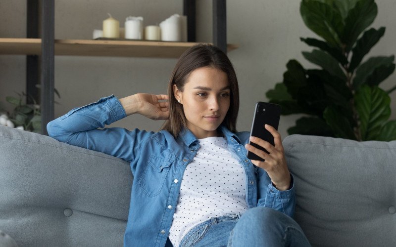 /assets/img/45943627-pretty-female-sitting-on-couch-holding-smartphone-posing.jpg
