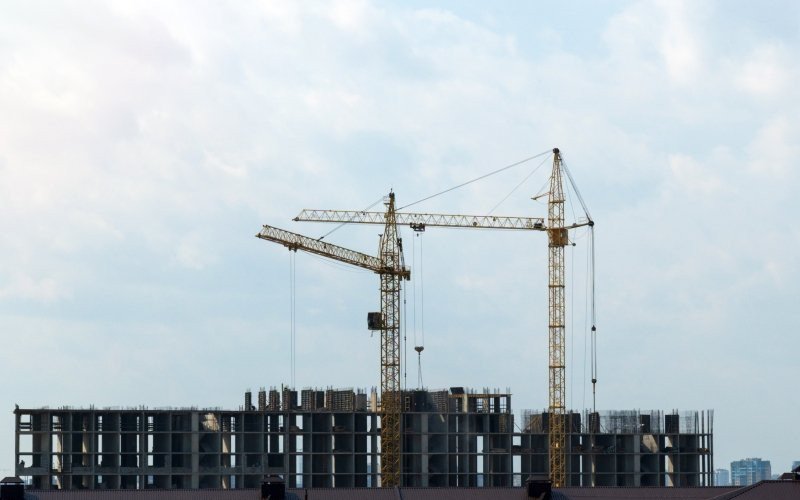 /assets/img/57982733-construction-cranes-construction-site-housing.jpg