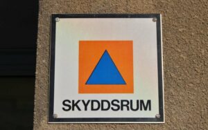 Alla byggnader med ett skyddsrum ska ha denna skylt. Foto: Maria Groth/Mostphotos